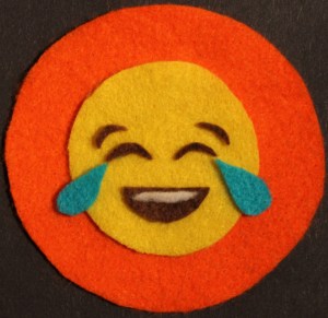 A felt image of a laughing face emoji