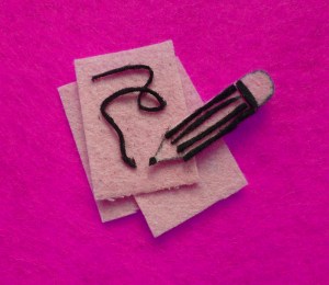 A felt image of a pencil and paper